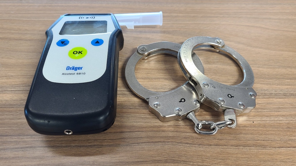 Handcuffs and a breathalyzer device are displayed.  (OPP_CR)