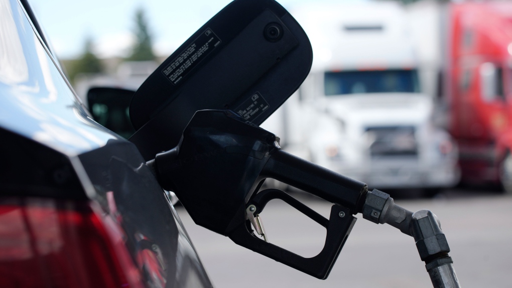 A pump handle hangs from a car at a gas station as motorists take to the road to start the Memorial Day weekend, Thursday, May 27, 2021, near Cheyenne, Wyo. (AP Photo/David Zalubowski) 
