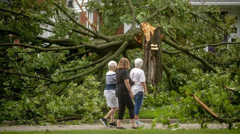 Flushing residents Donna Black, from left to right, Brenda Nyquist and Judy Doyle looks at the damage around their neighborhood (Jake May/The Flint Journal via AP)