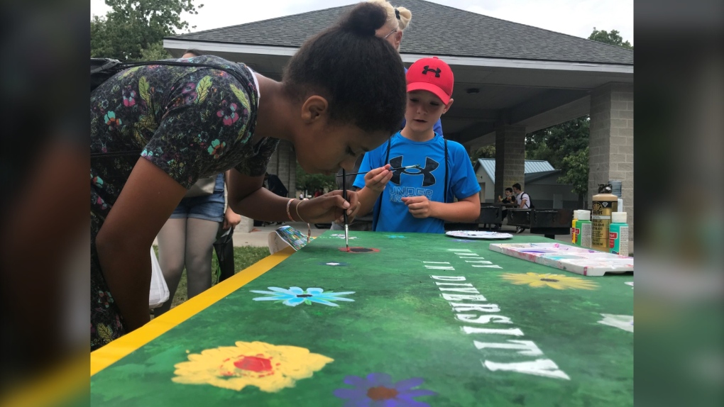 Young Windsorites add to the “Unity and Diversity” painting during the DiverCity BBQ on August 13, 2022. (Michelle Maluske/CTV News Windsor)