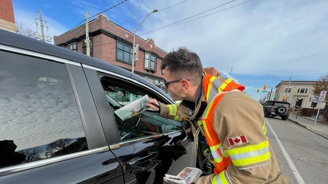 Korey Bremner with Windsor Fire and Rescue Services helping out with the Goodfellows paper drive on Wyandotte Street East in Windsor, Ont. on Saturday, Nov. 25, 2023. (Chris Campbell/CTV News Windsor)